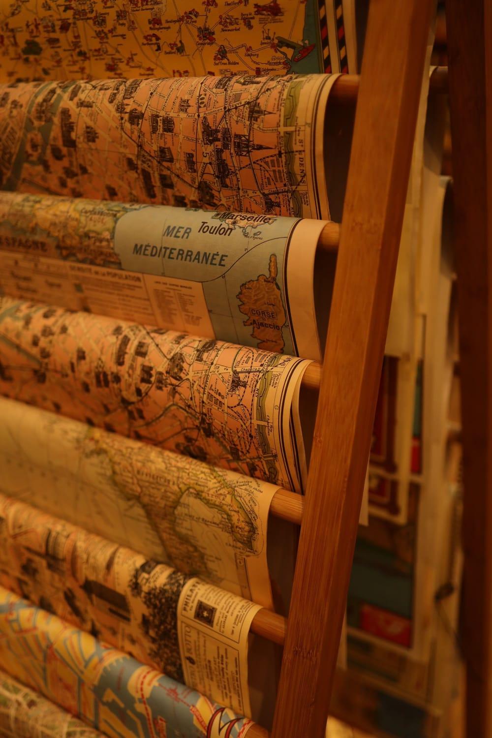 Rolled antique maps on a wooden rack